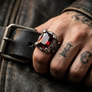 Model wearing a mens 925 sterling silver dragon claw ring featuring a natural red garnet gemstone in a gothic biker style