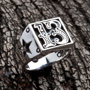 Top-angle view of the Number 13 sterling silver biker ring showing raised gothic numerals and cut-through star on shank