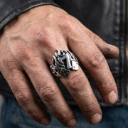 A close-up of a biker's hand wearing the large Number 7 Flame Dice Ring, showcasing the heavy silver design and intricate details under soft studio lighting.