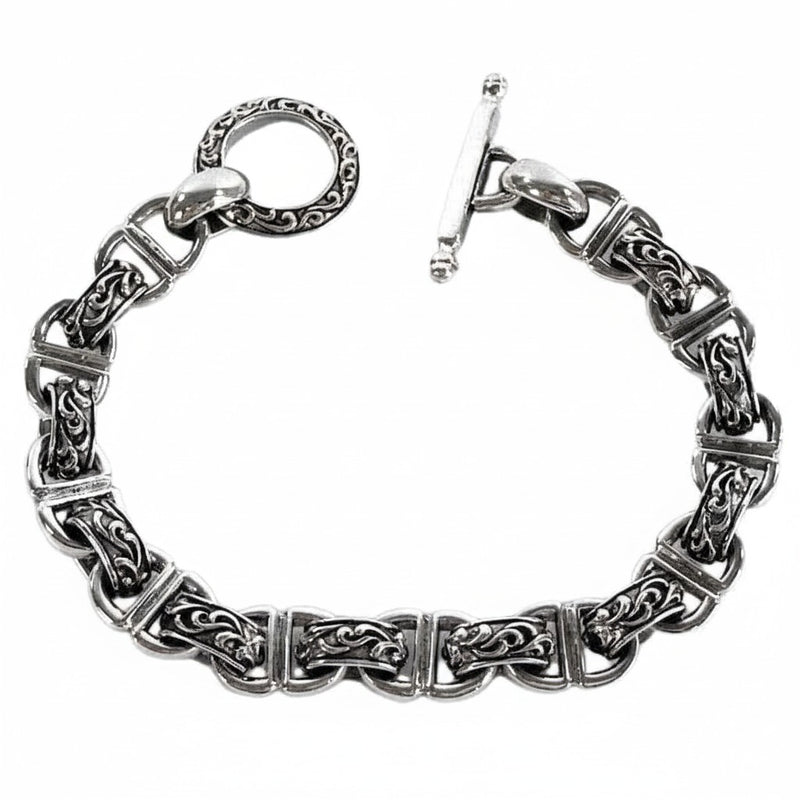 Das verzierte Armband aus 925er Sterlingsilber mit Tribal-Schnörkelgliedern und dekorativem T-Verschluss.