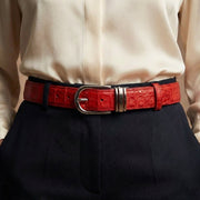 Red crocodile leather women's belt worn with navy trousers and cream silk blouse showing silver buckle detail