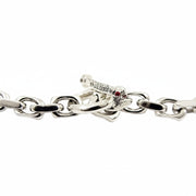 A close-up of the red garnet eye skull T-bar clasp on the men's silver curb chain necklace.