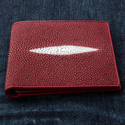 The exterior of a vibrant red stingray skin wallet showcasing its unique pebbly texture and distinctive white pearl mark.
