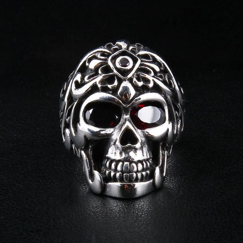 Straight-on view of a sterling silver skull ring wearing an intricate Roman centurion helmet with red garnet stone eyes.