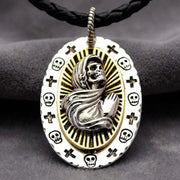 Santa Muerte pendant featuring a silver hooded skeleton figure with praying hands set against a gold sunburst background, surrounded by a white enamel border decorated with small skulls and crosses, hanging on a black braided leather cord