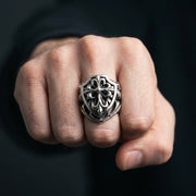 Homem a usar um anel gótico de cruz com escudo da fé em prata esterlina de 40 gramas no dedo médio com o punho cerrado.