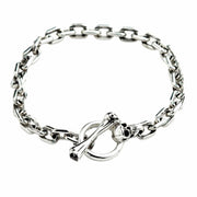 Top view of the skull T-bar sterling silver bracelet with chain laid in a circle.