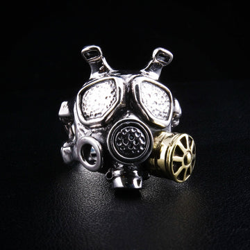 Um anel de máscara de gás em prata esterlina feito à mão com detalhes industriais steampunk e um filtro em latão.