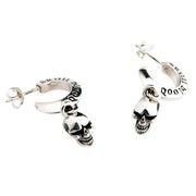 A premium pair of solid sterling silver dangle skull earrings with intricately engraved hoops, shown on a dark denim background.