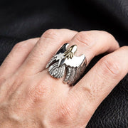 Bărbat purtând un inel din argint sterling cu un accent de cap din aur pe deget.