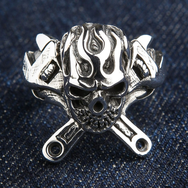 925 sterling silver flaming skull ring with crossed wrenches front view on denim background