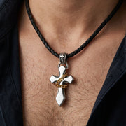 Man wearing sterling silver gothic cross pendant with gold chain accent on braided leather necklace