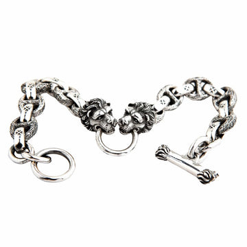 Sterling silver lion head bracelet with cross link chain displayed flat showing dual lion heads and T-bar clasp