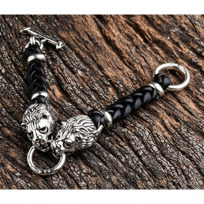 Armband aus Sterlingsilber mit Löwenkopf, schwarzem geflochtenem Leder und T-Verschluss auf Holzuntergrund