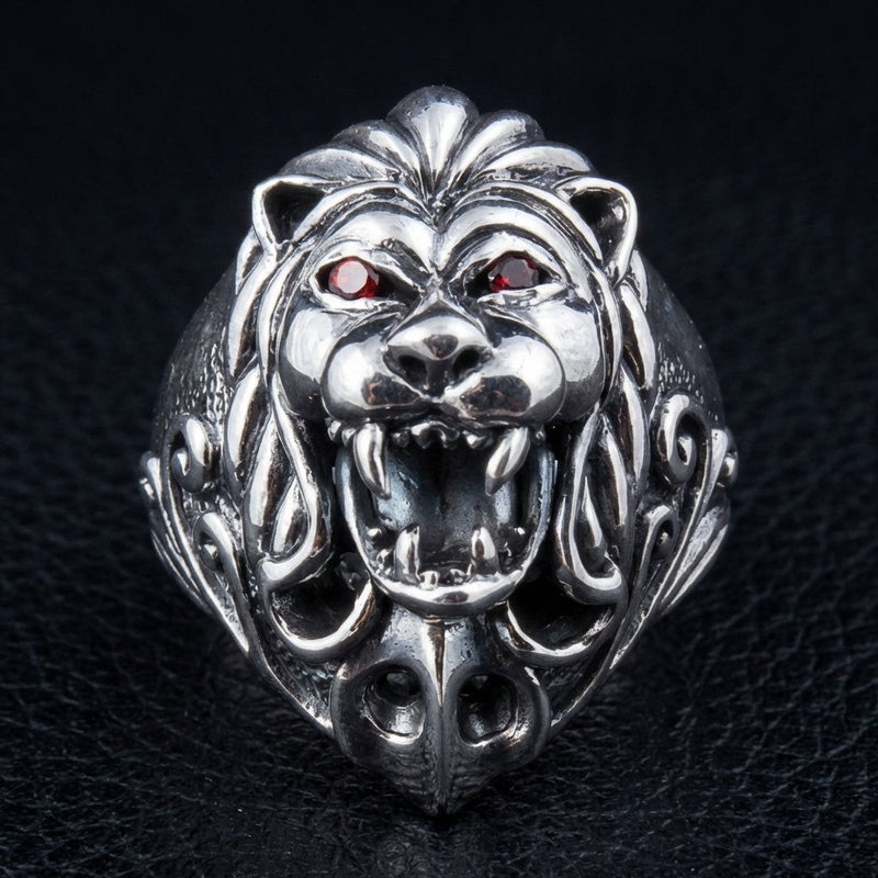 Sterling silver lion head ring with red garnet eyes front view showing roaring lion face and detailed mane