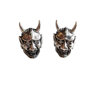 A pair of sterling silver Oni mask stud earrings with diamond CZ eyes.