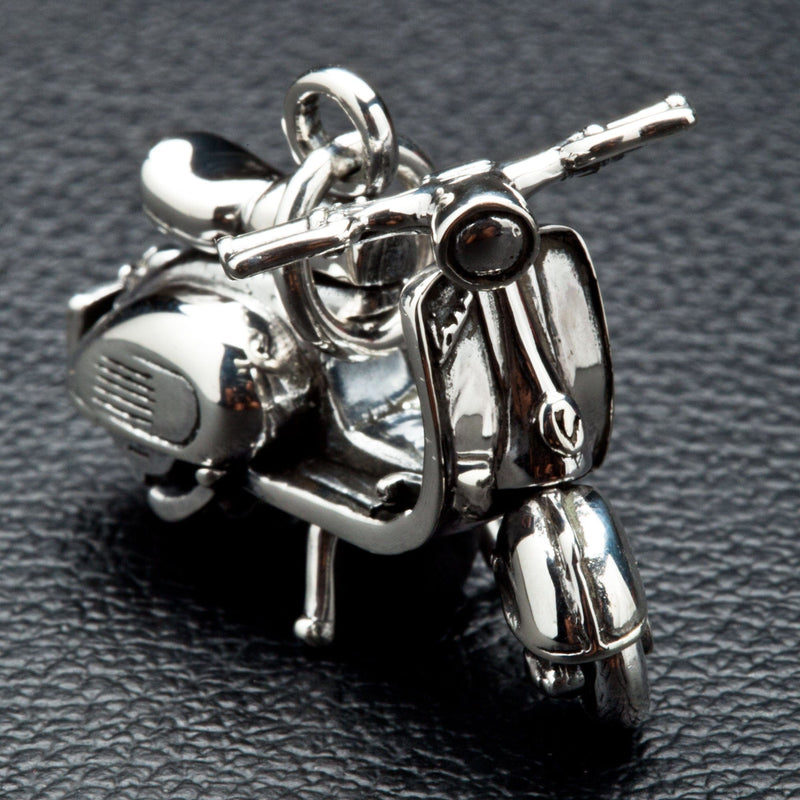 Front three-quarter view of a solid sterling silver scooter pendant featuring detailed handlebars, a polished headlight, and front fender.