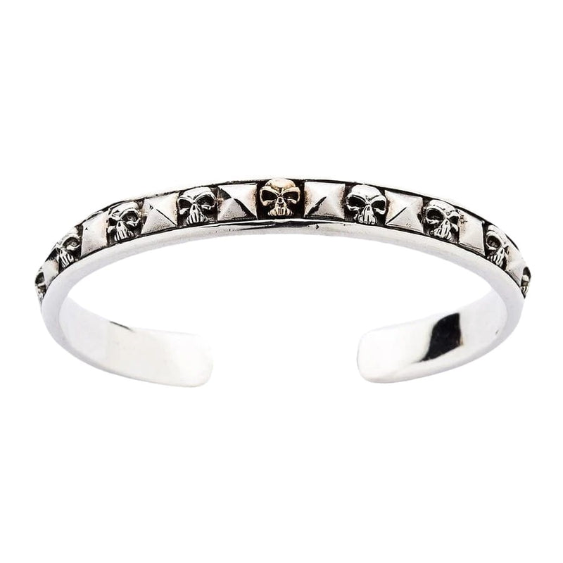 Sterling sølv kranium cuff armbånd med pyramide studs forfra, der viser detaljerede kraniummotiver