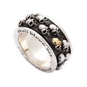 A sterling silver skull spinner ring with a gold skull accent, showing the engraved inner band.
