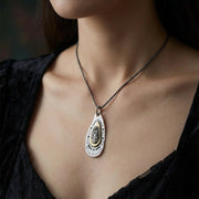 Woman wearing handcrafted sterling silver Virgin Mary pendant with unique skull details