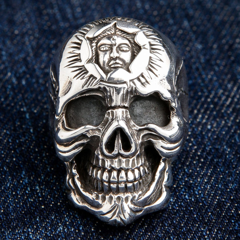 A close-up front view of the sun god skull ring, focusing on the intricate emblem carved into the forehead.