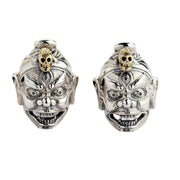 A front view of the two-tone Tibetan devil mask stud earrings, showing the silver face and brass skull.