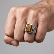 老虎眼石純銀男戒佩戴在手上,顯示出金棕色寶石和自然靈感的戒指設計