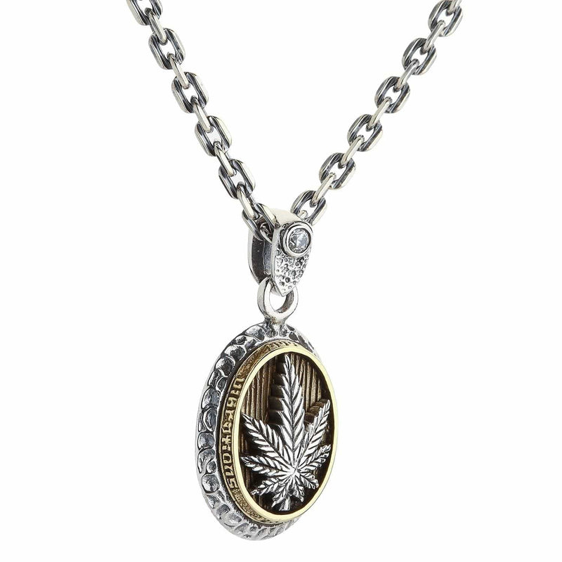 Un colgante de cannabis de dos tonos en plata esterlina y latón.