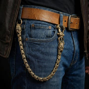 Modello che indossa una catena da portafoglio Viper Snake in ottone massiccio attaccata al passante della cintura dei jeans, che mostra dettagli intricati delle squame di serpente e uno stile di gioielleria pesante da biker.