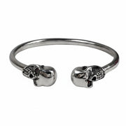 A handcrafted women's sterling silver skull cuff bracelet with garnet and diamond gemstone eyes.