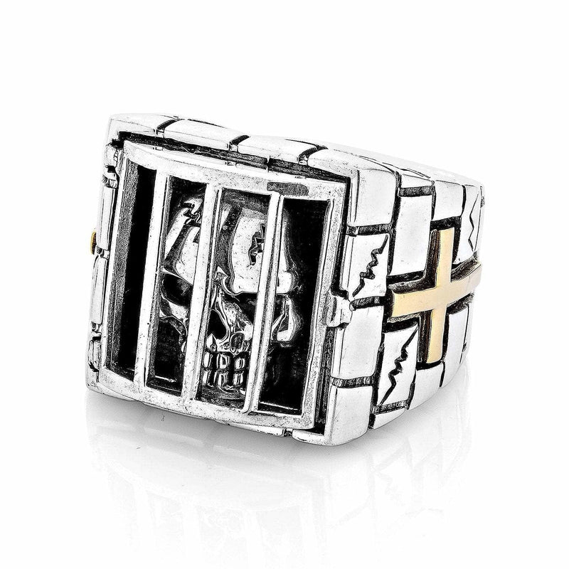 A solid sterling silver and gold prisoner skull ring, showing a detailed skull behind the bars of a prison cell.