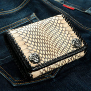The grey snake leather wallet displayed on blue denim to show texture and size.