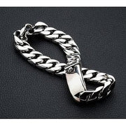 A men's heavy 11mm sterling silver curb chain bracelet with a high polish finish, resting on a black surface.