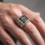 En modells hand som bär den massiva och detaljerade sterling silverfångskalringen för att demonstrera dess imponerande och modiga stil.