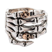 A sterling silver skeleton hand ring with a rose gold skull and gothic cross on top.