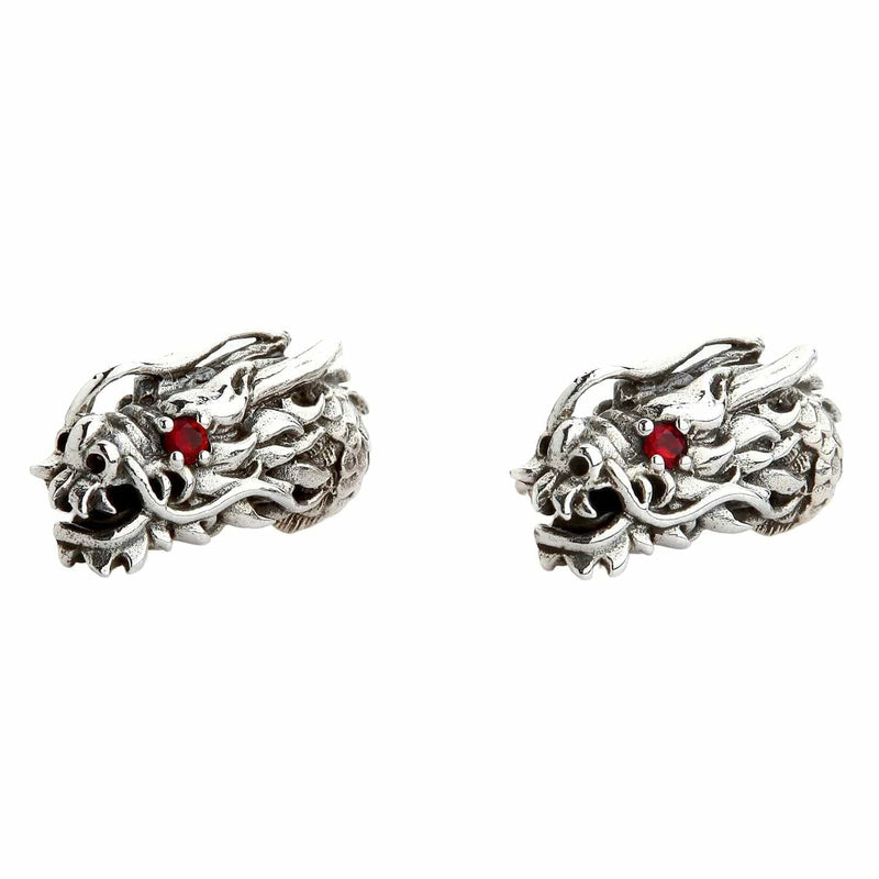 Una coppia di orecchini a spillo in argento sterling con testa di drago e occhi in granato rosso.