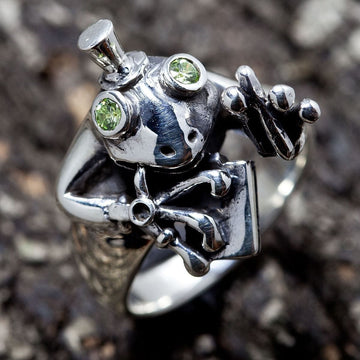 Sterling silver frog ring featuring a top hat and green gemstone eyes