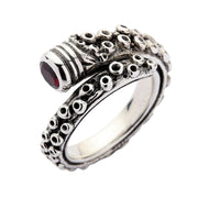 An angled view of the adjustable sterling silver octopus tentacle ring with a red CZ stone.