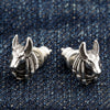 En par pärong sterling silver Anubis-öreringar, som visar den detaljerade jackalhuvade egyptiska guden på en denim-bakgrund.