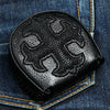 Billetera de cuero de raya negra con cruz gótica incrustada en un fondo de denim.