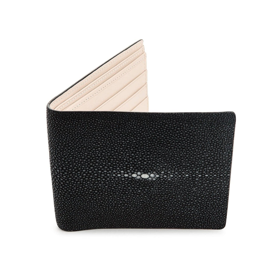 El exterior de una billetera de cuero de raya negra premium, mostrando la única textura de guijarros y la distintiva marca de perla blanca.
