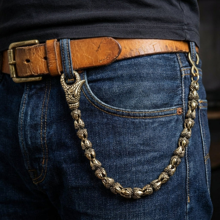 Mand iført messing dragekløft tegneklæde fastgjort til læderbælte og jeans forlommer i biker stil