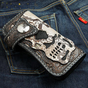 The hand-carved cobra skull biker wallet with stingray and leather details, shown closed on a pair of blue jeans.