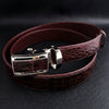 Dark brown genuine crocodile leather men's belt with silver automatic buckle displayed on black leather surface