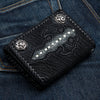 Cartera biker negra con cruz gótica de piel de mantarraya en un bolsillo trasero de jeans, broches plateados y bordes de cuero vacuno trenzado
