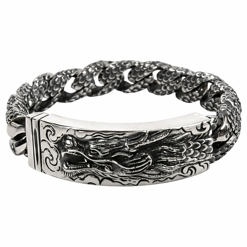 Close up of intricate dragon head carving on silver ID bracelet