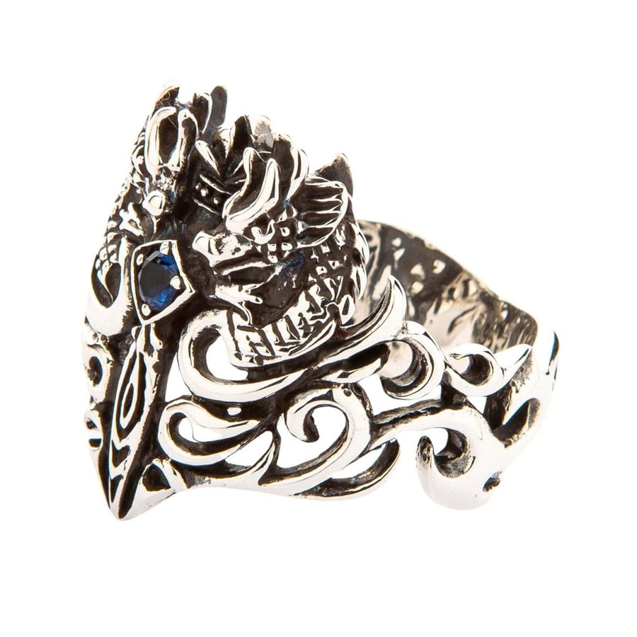 Side view of handcrafted sterling silver dragon ring showing intricate filigree scrollwork and blue gemstone