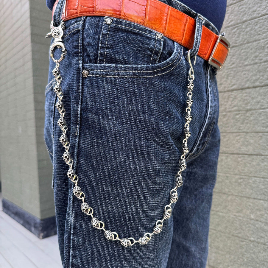 En man som bär bikerplånbokskedjan med brinnande dödskalle i massivt sterling silver.