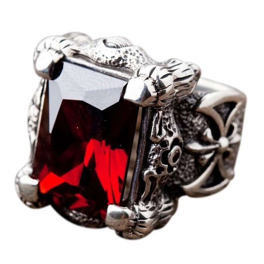 Un massiccio anello a drago di zanna in argento sterling, con quattro artigli dettagliati che tengono una grande pietra rossa fuoco tagliata a emerald.