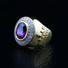Una corona de amatista dorada para anillo de obispo para hombres, que muestra el detalle intrincado de la corona en la banda y el brillante halo.